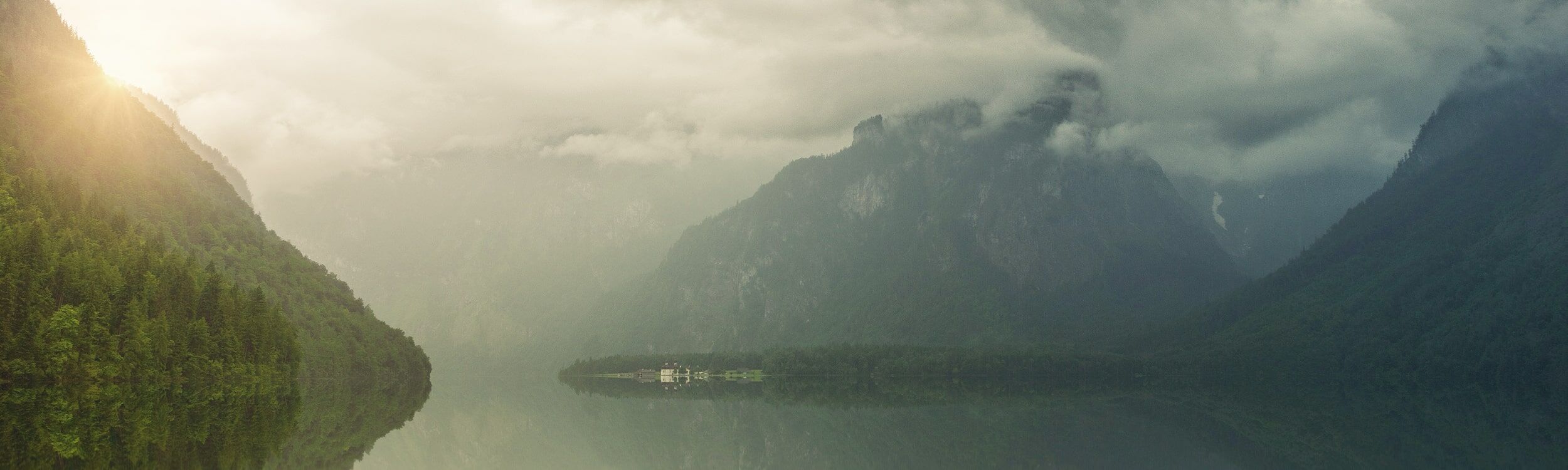 Header Philosophie | Ruhige Landschaft mit einem See & Bergen